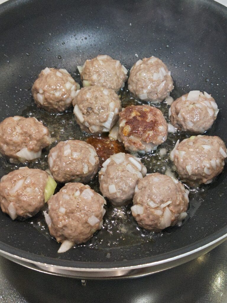 フライパンで６～７分蒸し焼きした後のミートボールの写真。ひとつ裏返して焼き色チェック