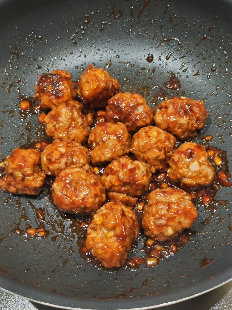 蒸し焼きしたミートボールにトマトソースの材料を加えてコロコロ転がしながら煮詰めた出来上がり写真
