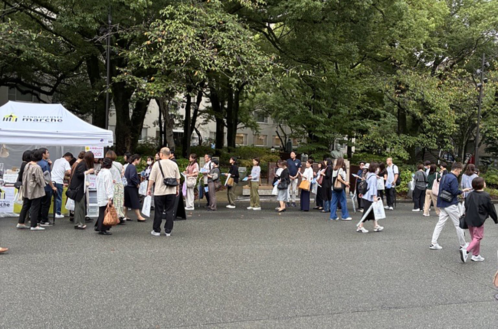 カンダイパンセマルシェのテントに商品をもって行列を作る人々