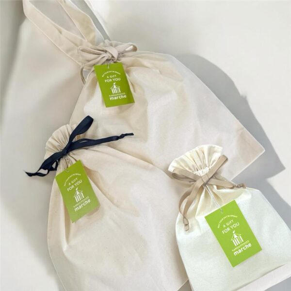 SMLサイズの巾着が机の上に交差して並んでいる写真