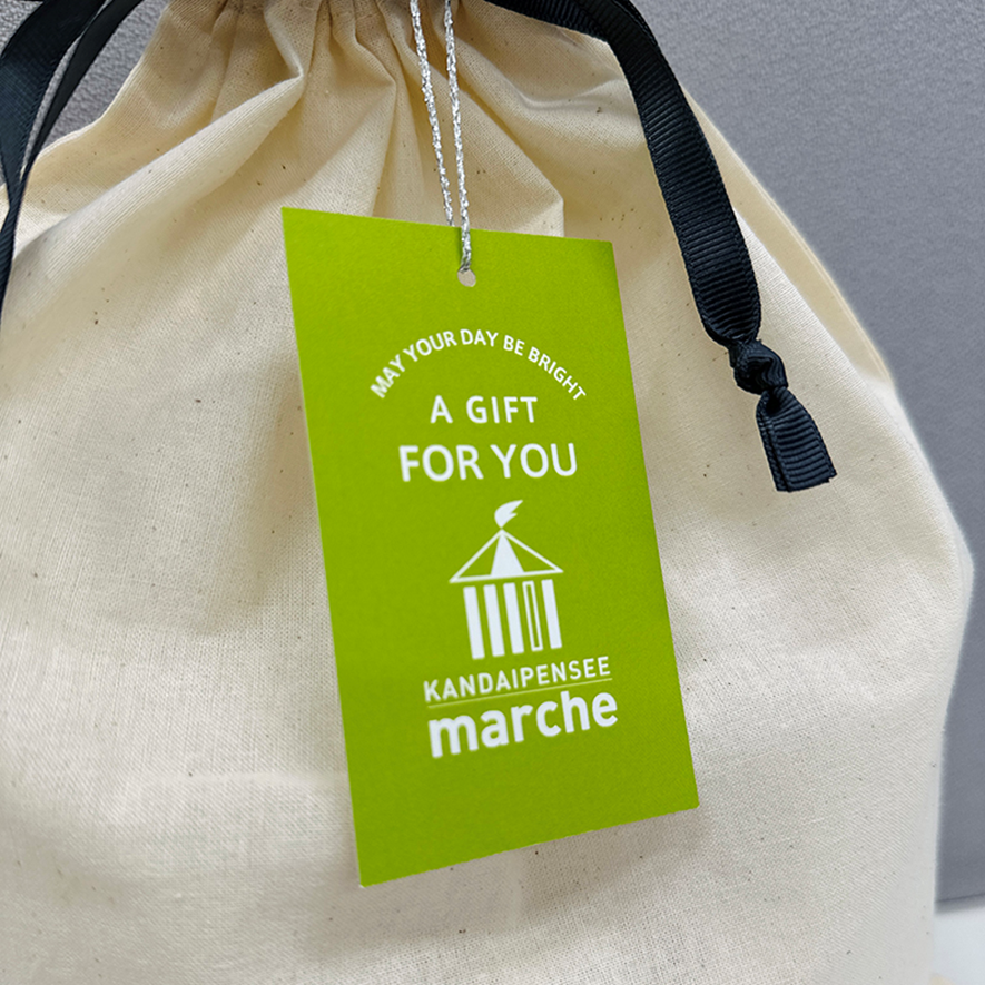 コットン巾着袋に添えているカンダイパンセマルシェのオリジナルタグのアップの写真