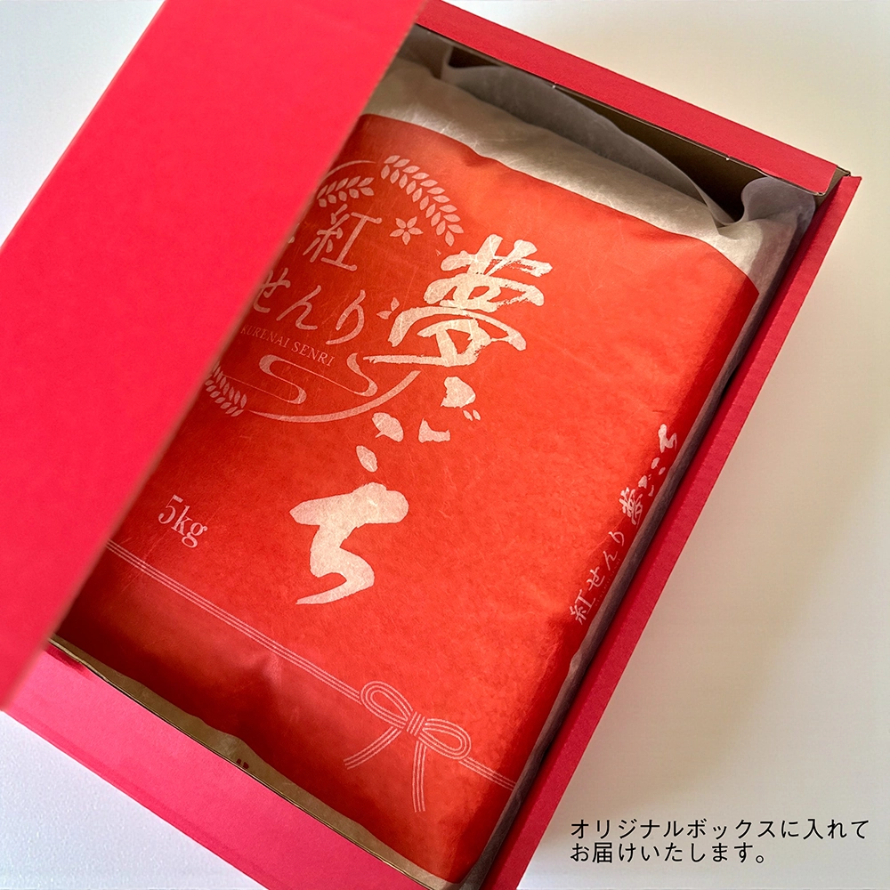 赤いギフトボックスに入った5kgの米袋。米袋は白地に赤いラベルがあり、『紅せんり 夢ごこち』と印字されています。ラベルには稲穂の装飾とリボンのイラストが描かれています