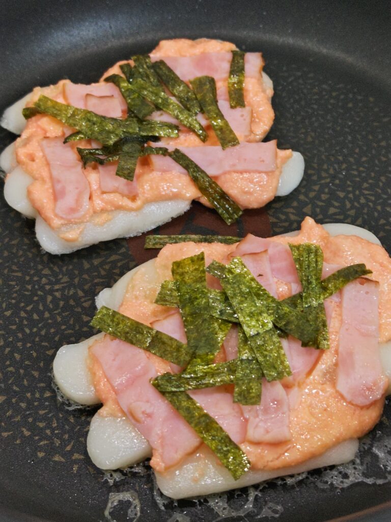 フライパンで蒸し焼きしたおもちピザ。トッピングは、たらこマヨ、ベーコン、海苔です。